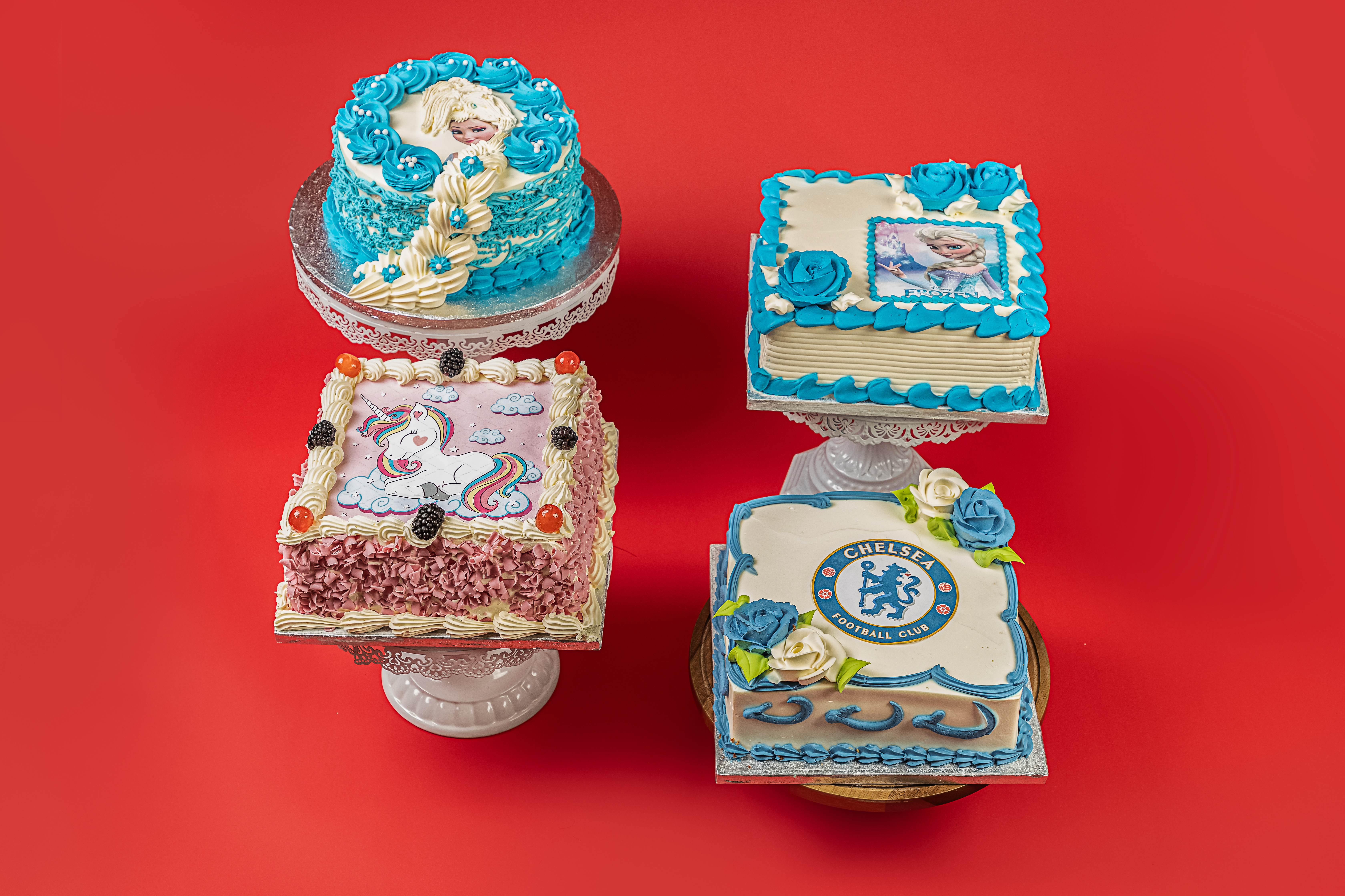 Three celebration cakes on stands.