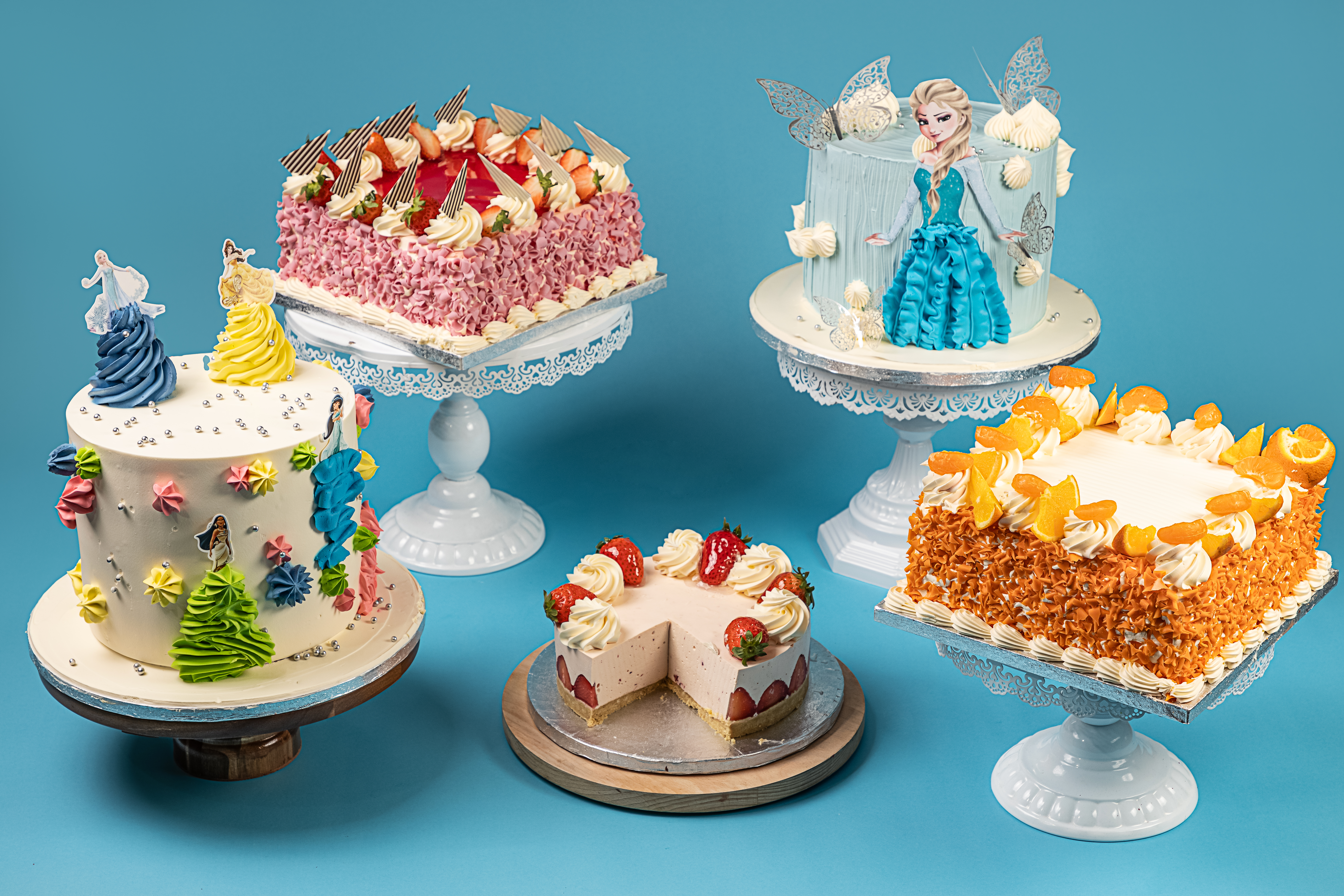 Three celebration cakes on stands.